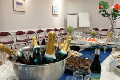 Manoir ancien entouré d'arbres, avec une pelouse en premier plan et un ciel clair en arrière-plan.