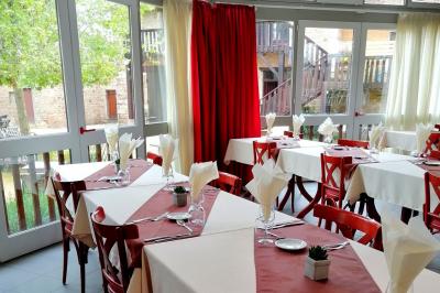 Manoir ancien entouré d'arbres, avec une pelouse en premier plan et un ciel clair en arrière-plan.