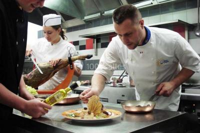 Un chef pâtissier décore un dessert raffiné dans une cuisine professionnelle.
