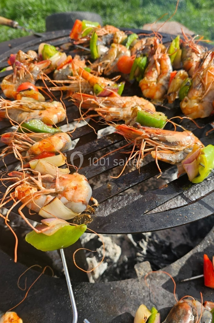 Crevettes et légumes colorés grillés sur une grille de barbecue en plein air.