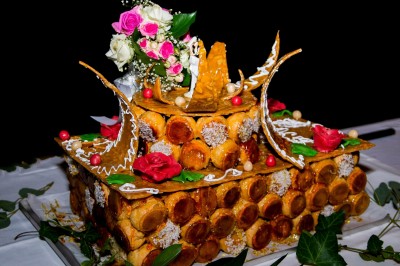 Un chef pâtissier décore un dessert raffiné dans une cuisine professionnelle.