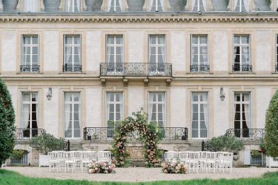 Manoir ancien entouré d'arbres et de buissons sous la neige, éclairé par une lumière hivernale douce.