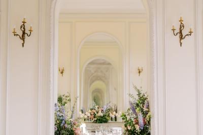 Manoir ancien entouré d'arbres et de buissons sous la neige, éclairé par une lumière hivernale douce.