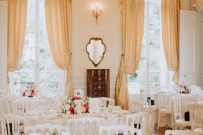 Manoir ancien entouré d'arbres et de buissons sous la neige, éclairé par une lumière hivernale douce.