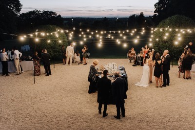 Manoir ancien entouré d'arbres et de buissons sous la neige, éclairé par une lumière hivernale douce.