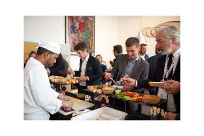 Groupe de personnes en vêtements d'hiver rassemblées dans une pièce éclairée par une lumière bleutée.
