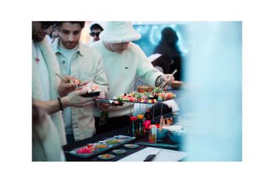 Groupe de personnes en vêtements d'hiver rassemblées dans une pièce éclairée par une lumière bleutée.
