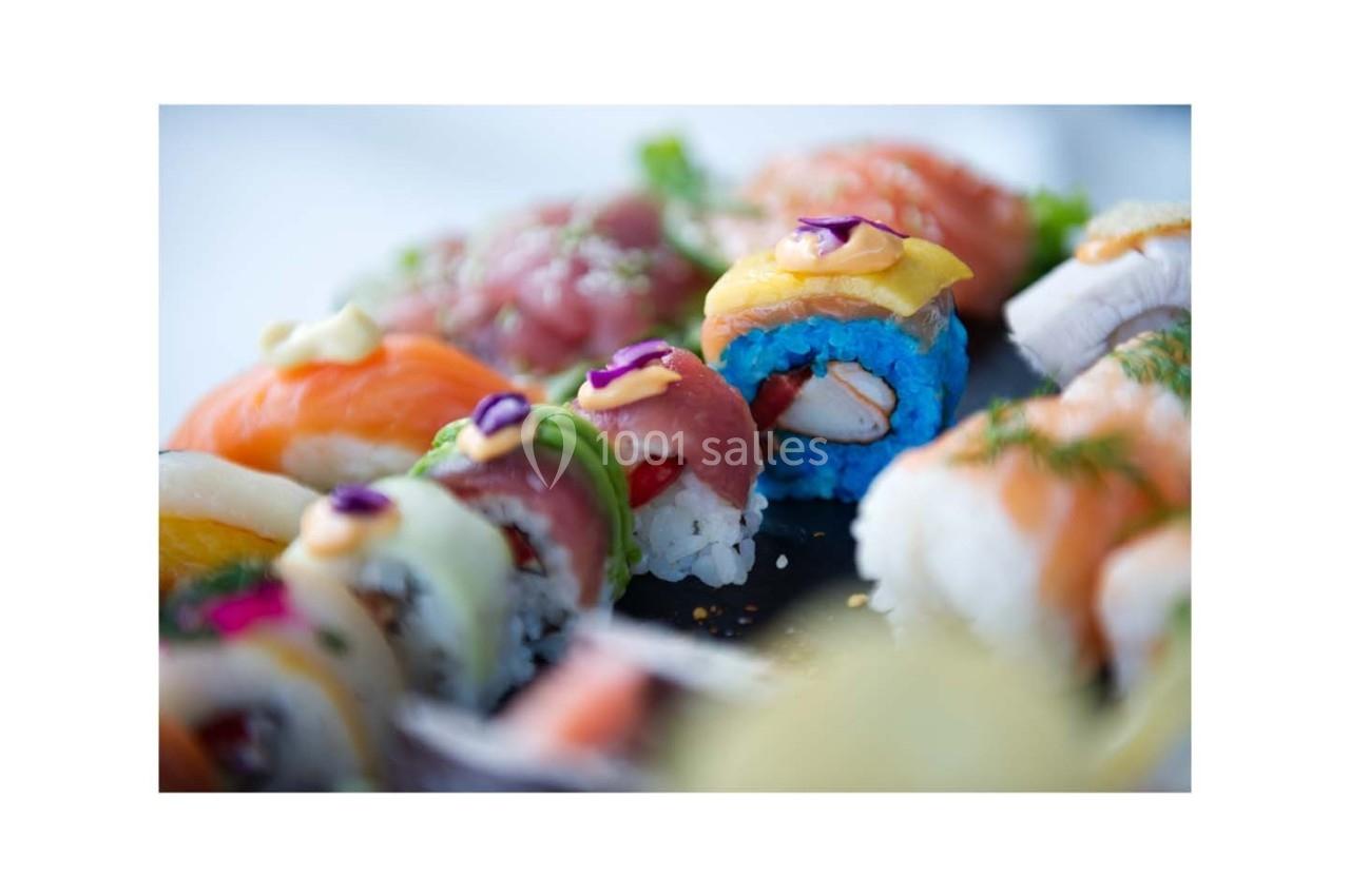Assortiment de sushis colorés avec différents ingrédients, présenté sur une assiette.