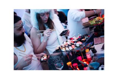 Groupe de personnes en vêtements d'hiver rassemblées dans une pièce éclairée par une lumière bleutée.