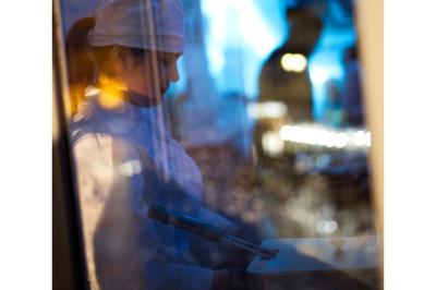 Groupe de personnes en vêtements d'hiver rassemblées dans une pièce éclairée par une lumière bleutée.