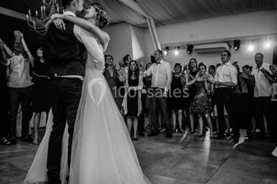 Table dressée avec nappes blanches, verres et couverts, vue sur une terrasse avec piscine et chaises en arrière-plan.