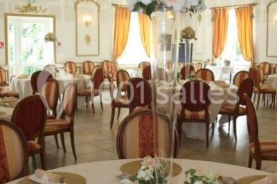 Chambre classique avec lit double, mobilier en bois, rideaux dorés et lumière naturelle entrant par une fenêtre.