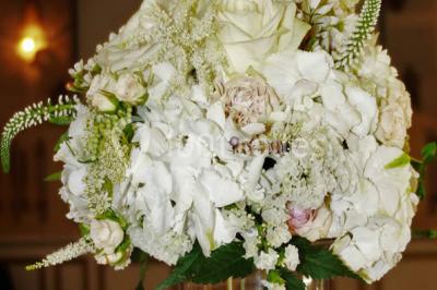 Chambre classique avec lit double, mobilier en bois, rideaux dorés et lumière naturelle entrant par une fenêtre.