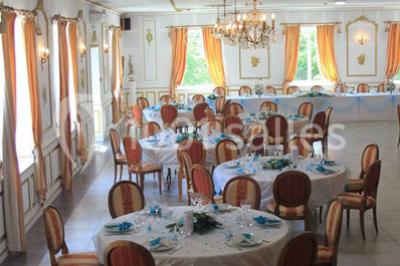 Chambre classique avec lit double, mobilier en bois, rideaux dorés et lumière naturelle entrant par une fenêtre.