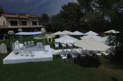 Table élégamment dressée avec chandeliers, verres et décorations sous un plafond illuminé de guirlandes lumineuses.