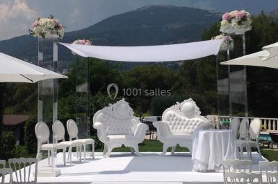 Table élégamment dressée avec chandeliers, verres et décorations sous un plafond illuminé de guirlandes lumineuses.