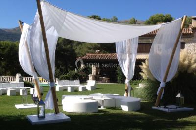 Table élégamment dressée avec chandeliers, verres et décorations sous un plafond illuminé de guirlandes lumineuses.