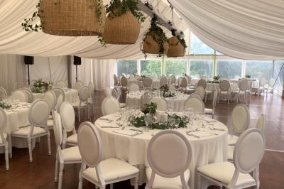 Table élégamment dressée avec chandeliers, verres et décorations sous un plafond illuminé de guirlandes lumineuses.