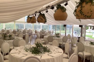 Table élégamment dressée avec chandeliers, verres et décorations sous un plafond illuminé de guirlandes lumineuses.