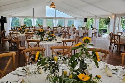 Table élégamment dressée avec chandeliers, verres et décorations sous un plafond illuminé de guirlandes lumineuses.