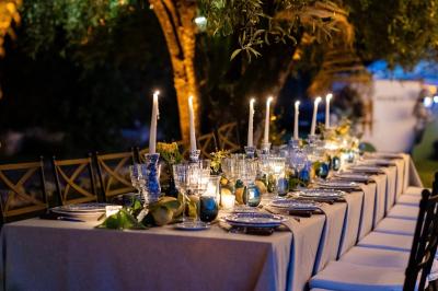 Table élégamment dressée avec chandeliers, verres et décorations sous un plafond illuminé de guirlandes lumineuses.
