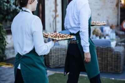 Des personnes discutent en petits groupes lors d'un événement dans une salle élégante avec des vitraux et une fresque murale.