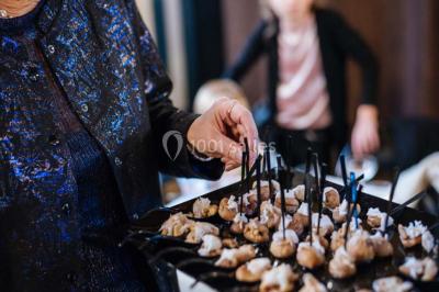 Des personnes discutent en petits groupes lors d'un événement dans une salle élégante avec des vitraux et une fresque murale.