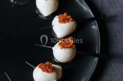 Des personnes discutent en petits groupes lors d'un événement dans une salle élégante avec des vitraux et une fresque murale.