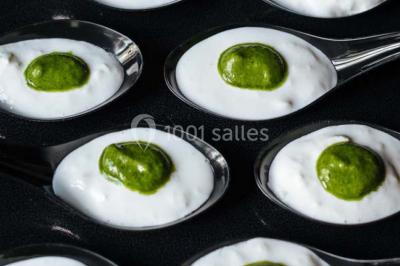 Des personnes discutent en petits groupes lors d'un événement dans une salle élégante avec des vitraux et une fresque murale.