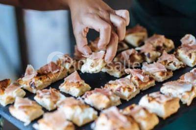 Des personnes discutent en petits groupes lors d'un événement dans une salle élégante avec des vitraux et une fresque murale.