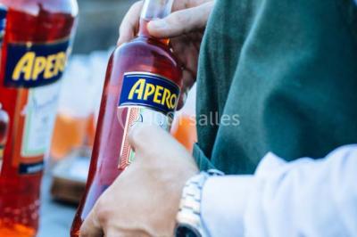 Des personnes discutent en petits groupes lors d'un événement dans une salle élégante avec des vitraux et une fresque murale.