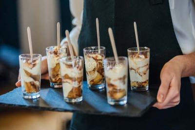 Des personnes discutent en petits groupes lors d'un événement dans une salle élégante avec des vitraux et une fresque murale.