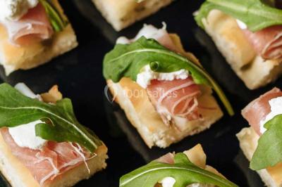 Miniature Traiteur Paris (Paris) - Profumo Traiteur Italien #3 Des personnes discutent debout lors d'un événement dans une salle élégante avec des vitraux et une fresque murale.