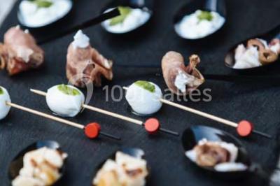 Miniature Traiteur Paris (Paris) - Profumo Traiteur Italien #5 Des personnes discutent debout lors d'un événement dans une salle élégante avec des vitraux et une fresque murale.
