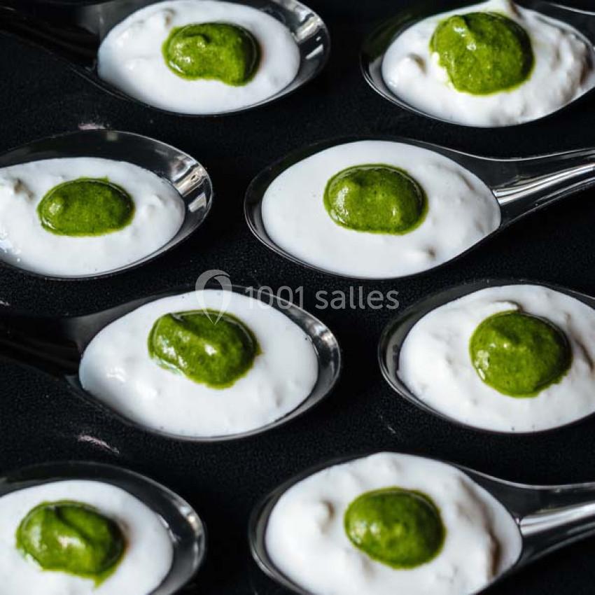 Traiteur Paris (Paris) - Profumo Traiteur Italien #11 Cuillères contenant une mousse blanche garnie d'une touche de sauce verte, disposées sur une surface noire.