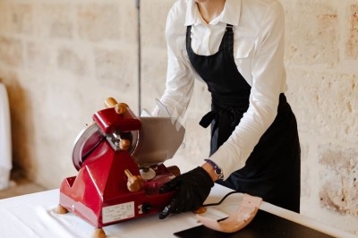Buffet en extérieur avec divers plats et amuse-bouches disposés sur des présentoirs, entouré de verdure et de fleurs.