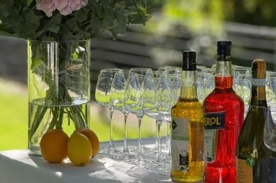 Buffet en extérieur avec divers plats et amuse-bouches disposés sur des présentoirs, entouré de verdure et de fleurs.