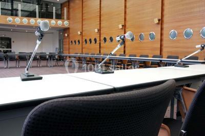Salle de réunion lumineuse avec table ovale, chaises, paperboard et vue sur la Tour Eiffel à travers de grandes fenêtres.