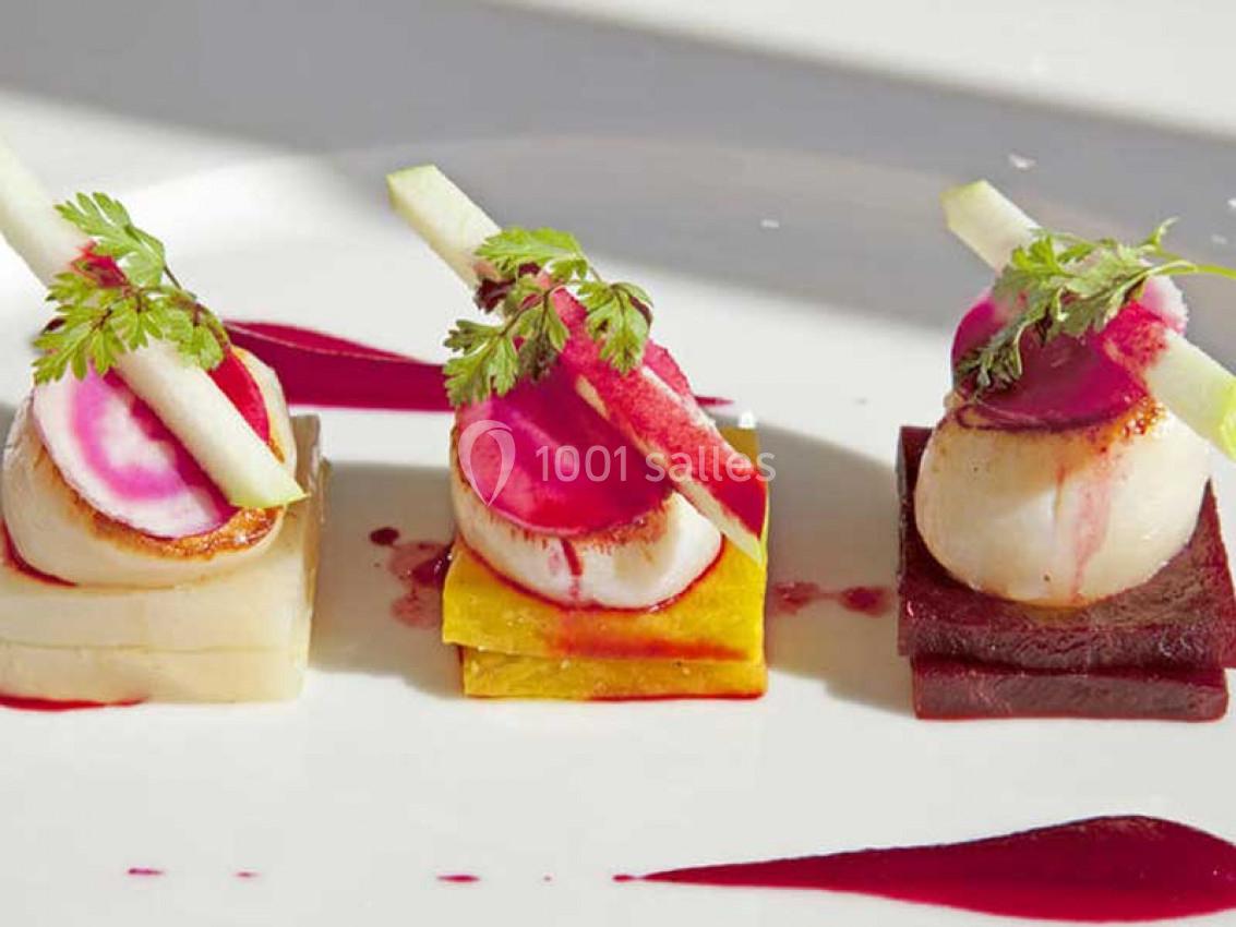 Assiette gastronomique avec trois bouchées composées de légumes colorés, noix de Saint-Jacques et garnitures raffinées.