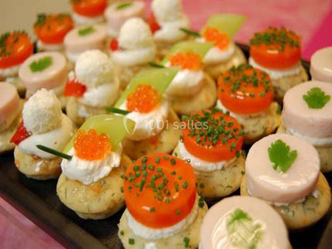Plateau de petits canapés variés garnis de légumes, fromage, œufs de poisson et décorations colorées.