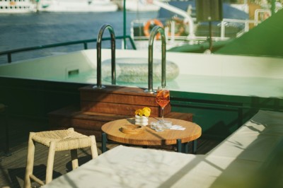 Vue d'un escalier menant à une terrasse animée avec des personnes discutant autour de tables et de plantes.