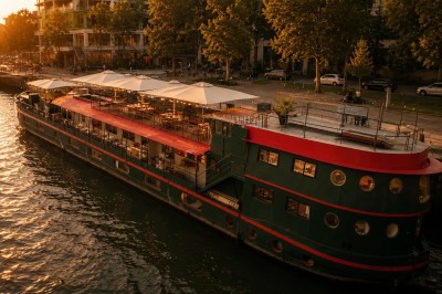 Miniature Location salle Paris 13 (Paris) - Le Playtime #2 Bateau de croisière moderne naviguant sur un canal, accompagné de deux bateaux plus petits, près d'une terrasse animée.