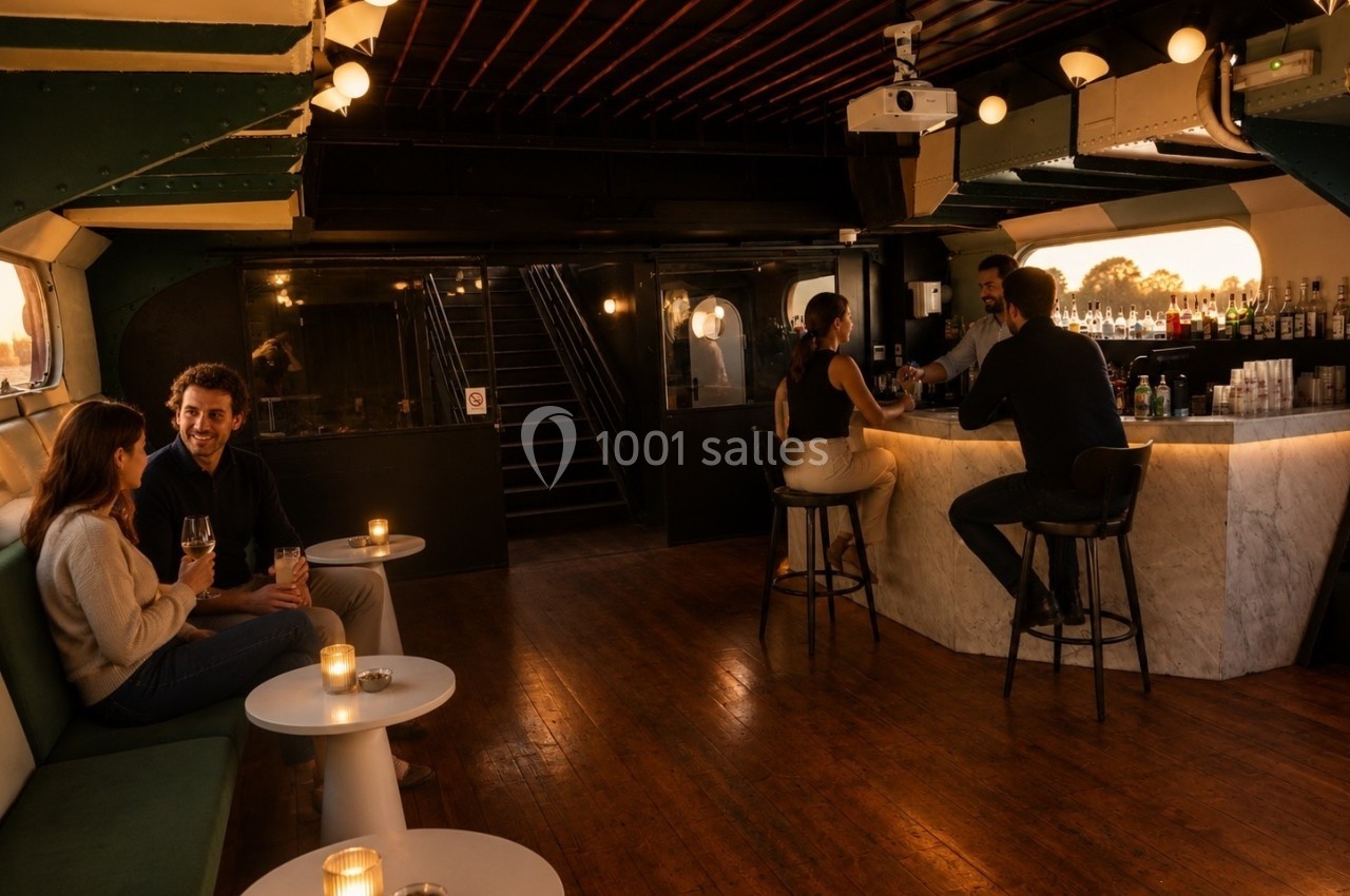 Un bar élégant avec des clients discutant autour de tables et du comptoir, éclairé par une lumière tamisée.