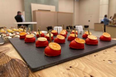 Dessert au chocolat garni de mangue, copeaux de noix de coco et pistaches, présenté sur une assiette verte.