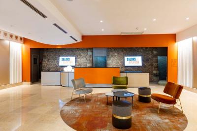 Dessert au chocolat garni de mangue, copeaux de noix de coco et pistaches, présenté sur une assiette verte.