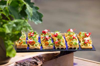Dessert au chocolat garni de mangue, copeaux de noix de coco et pistaches, présenté sur une assiette verte.