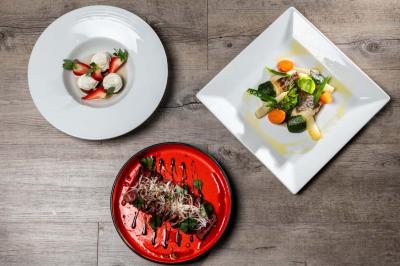 Dessert au chocolat garni de mangue, copeaux de noix de coco et pistaches, présenté sur une assiette verte.