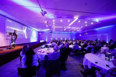 Dessert au chocolat garni de mangue, copeaux de noix de coco et pistaches, présenté sur une assiette verte.
