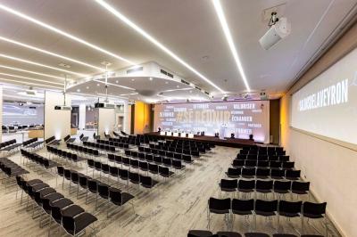 Dessert au chocolat garni de mangue, copeaux de noix de coco et pistaches, présenté sur une assiette verte.