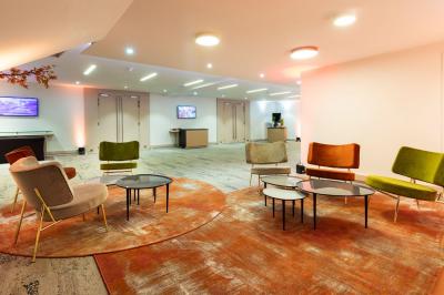 Dessert au chocolat garni de mangue, copeaux de noix de coco et pistaches, présenté sur une assiette verte.